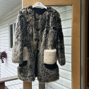 A beautiful shearling coat with patch pockets, hook and eye closure.